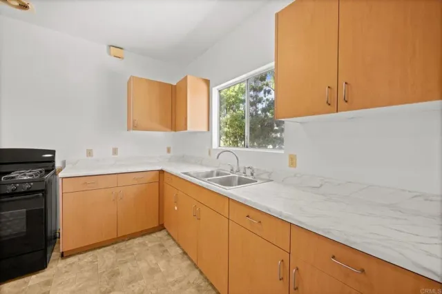 a view of an empty room with chandelier fan and fire place