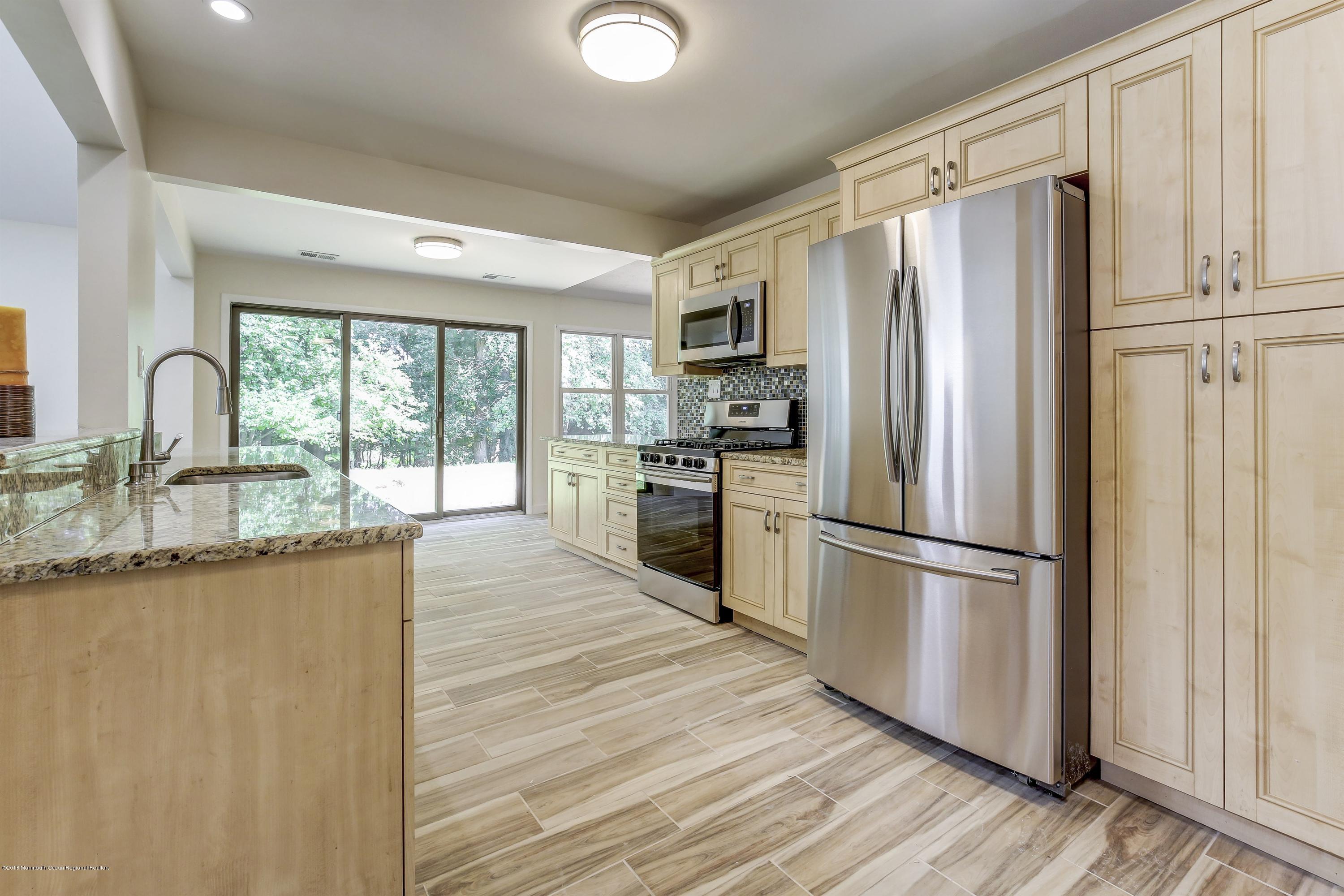 38 Dutch Valley Road Howell, NJ 07731 - Photo 2 of 20 a kitchen with granite countertop a refrigerator sink and cabinets