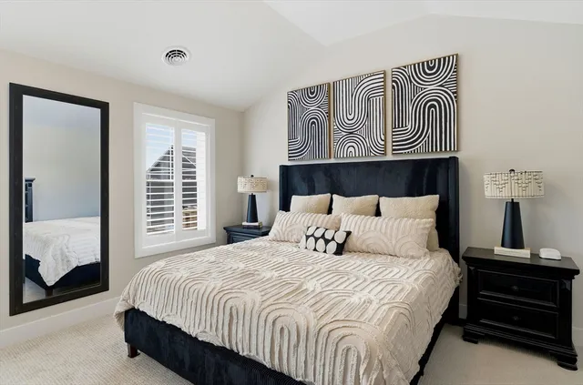 a bedroom with a bed and a mirror