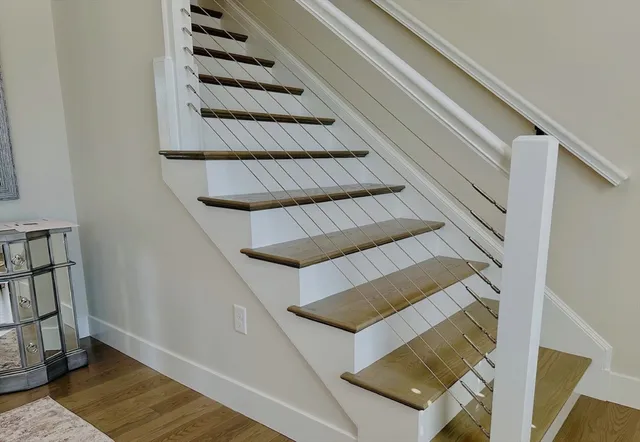 a view of staircase with wooden floor and white walls