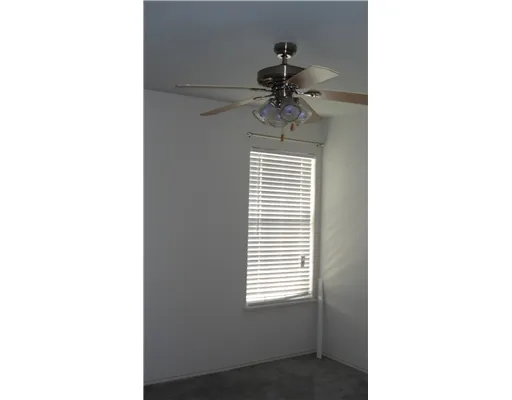 a view of a room with a window and a ceiling fan