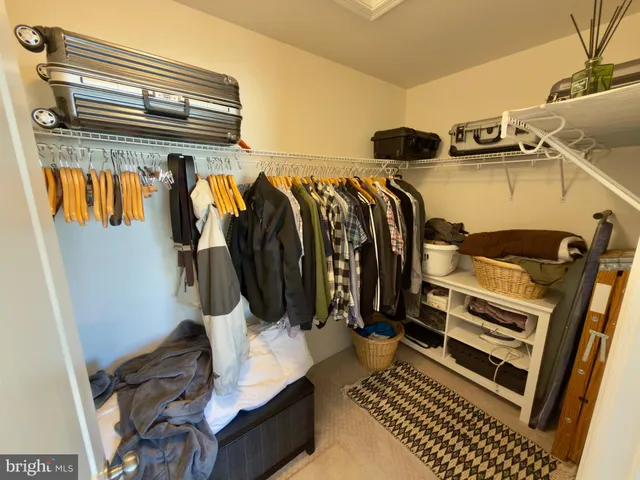a view of walk in closet with clothes and shoes