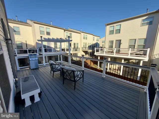 a balcony with wooden floor table and chairs