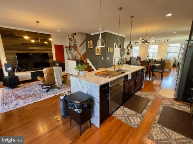 a living room with furniture a rug kitchen view and a chandelier