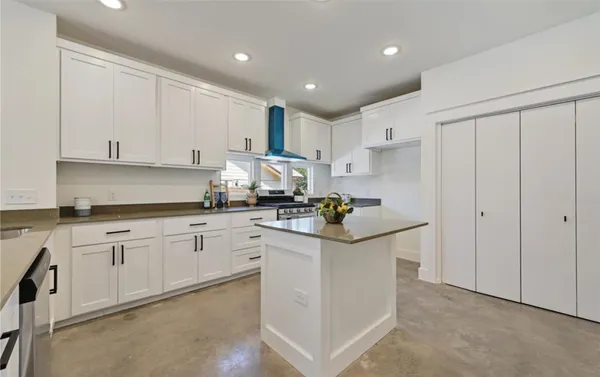 a kitchen with granite countertop white cabinets and white appliances