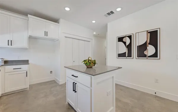 a room with white cabinets and painting on the wall