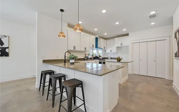 a kitchen with kitchen island granite countertop a sink a center island and appliances