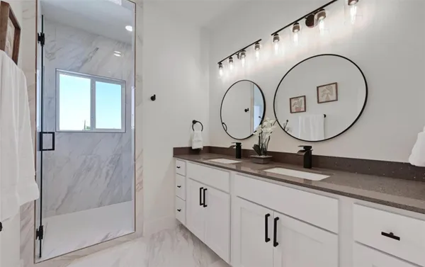 a bathroom with a granite countertop sink a mirror and a shower