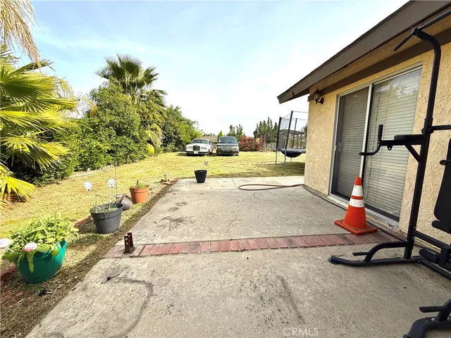 a view of a swimming pool with a lounge chair and potted plants