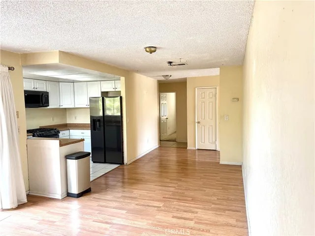 a view of a kitchen with a sink and a refrigerator