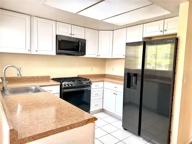 a kitchen with granite countertop a refrigerator stove and microwave