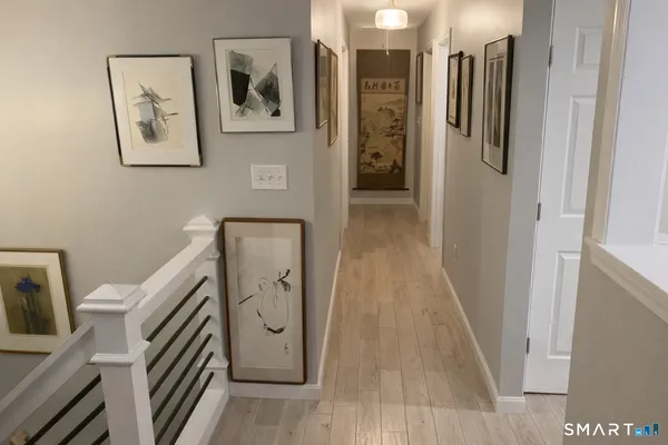 a view of a hallway with closet and wooden floor