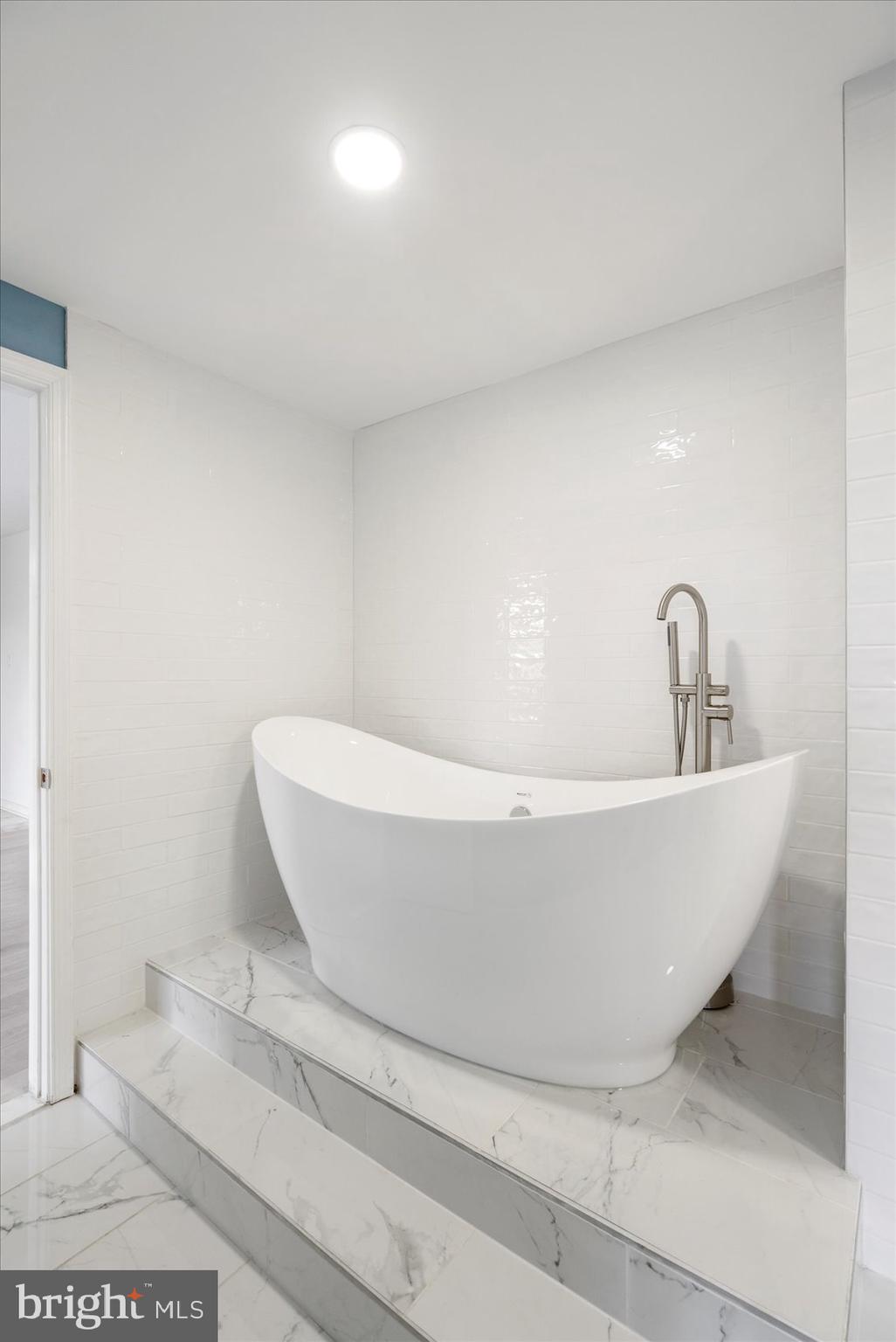 7111 Park Heights Avenue, Unit 305 Baltimore, MD 21215 - Photo 20 of 33 a white bath tub sitting in a bathroom
