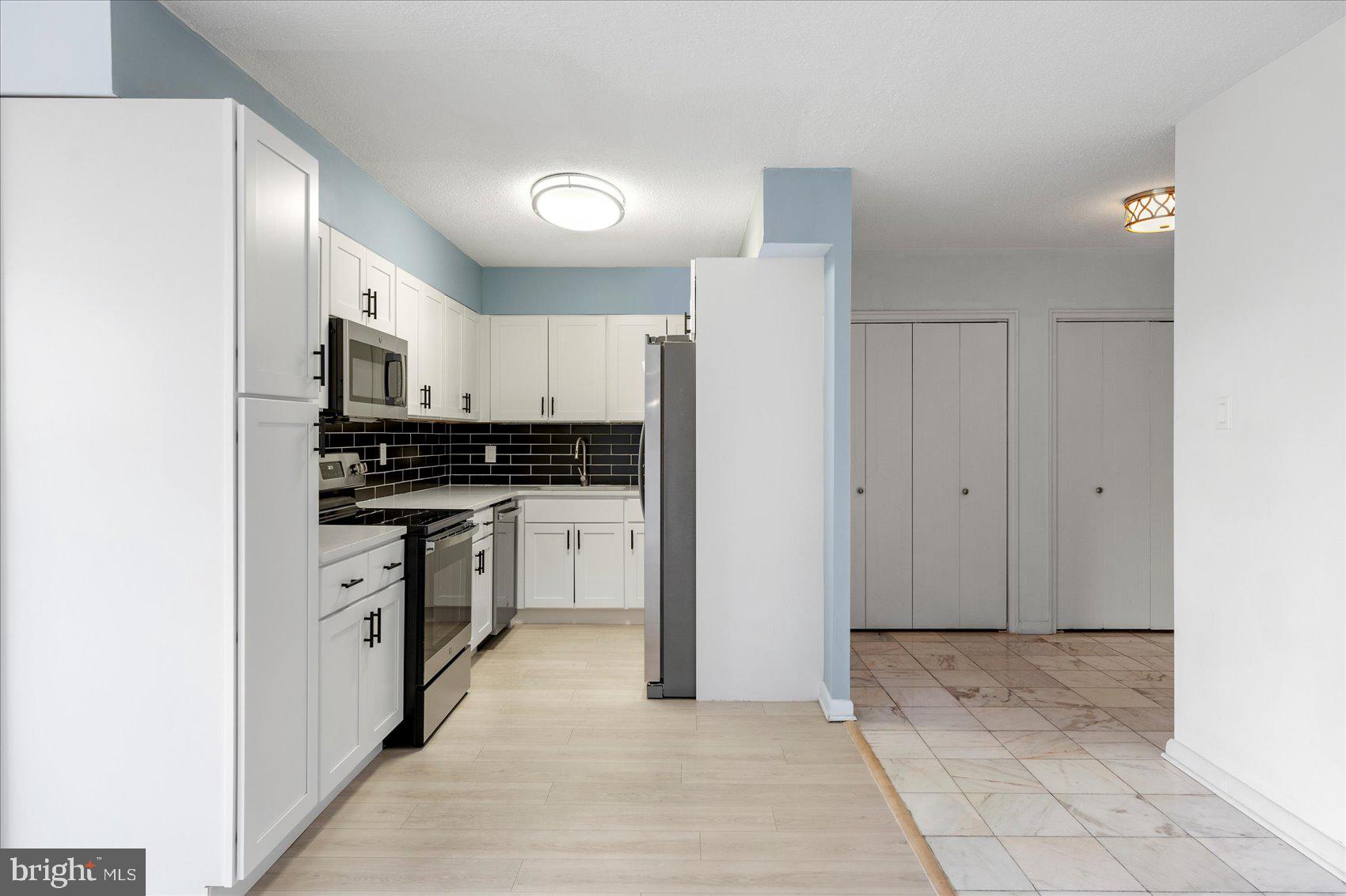 7111 Park Heights Avenue, Unit 305 Baltimore, MD 21215 - Photo 2 of 33 a kitchen with white cabinets and appliances