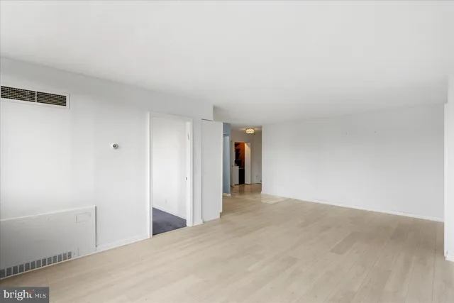 an empty room with windows and view of a balcony