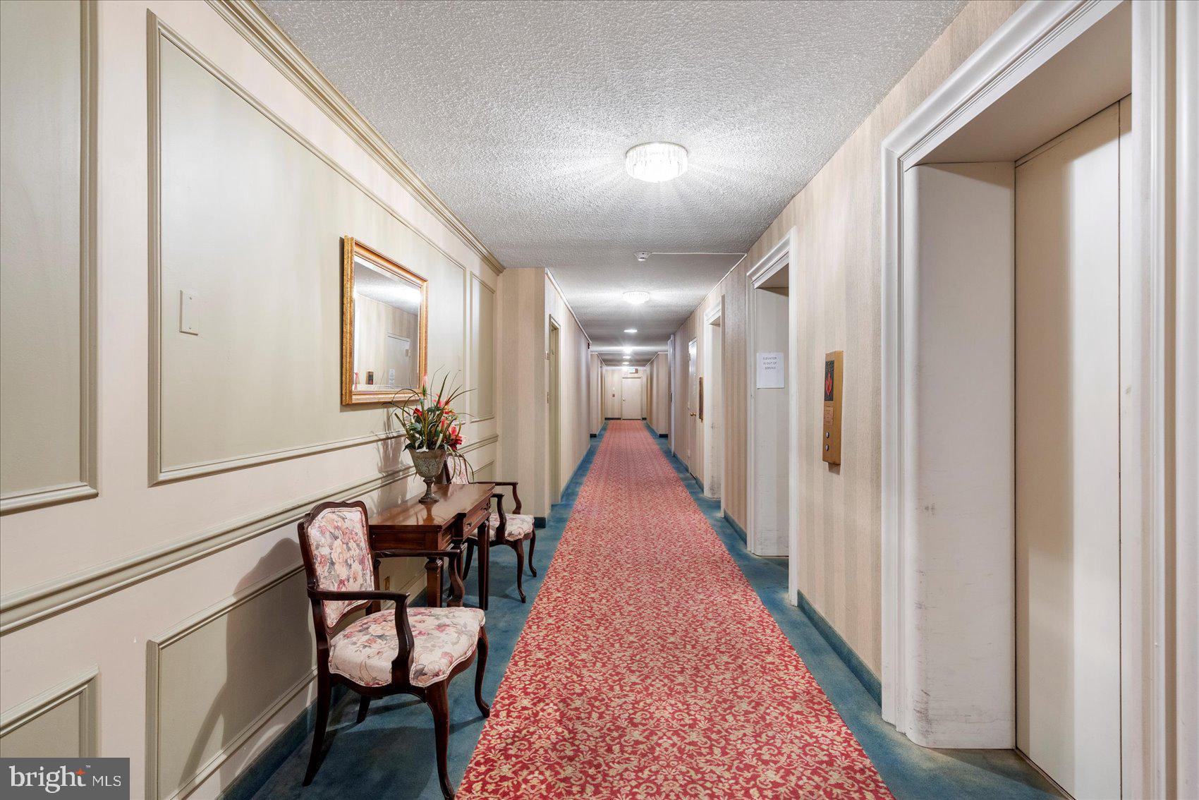 7111 Park Heights Avenue, Unit 305 Baltimore, MD 21215 - Photo 30 of 33 a hallway with chairs and rug