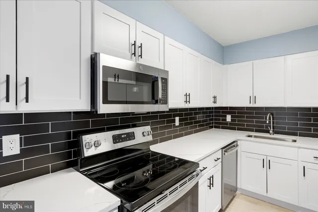 a view of kitchen with stainless steel appliances kitchen area and refrigerator