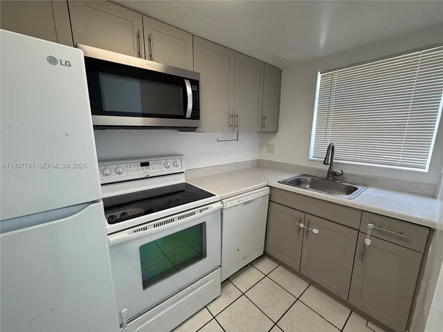 a kitchen with stainless steel appliances a stove microwave and sink