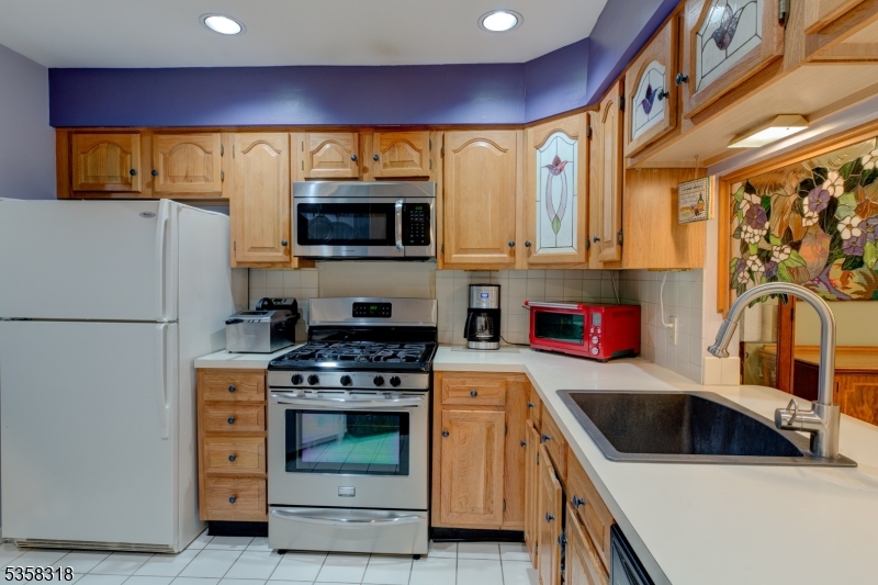 a kitchen with stainless steel appliances a stove a sink and a microwave