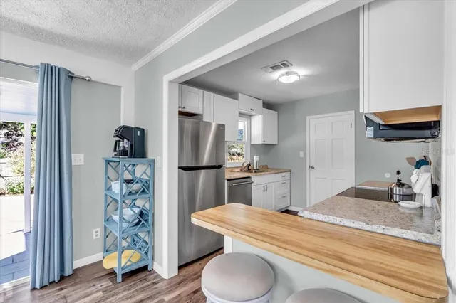 a kitchen with stainless steel appliances kitchen island granite countertop a refrigerator a stove and a sink