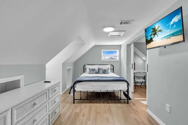 a bedroom with a bed and a flat tv screen on dresser