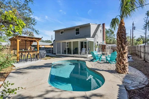 a view of a house with backyard and sitting area