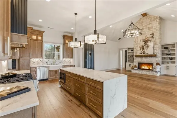 a kitchen with a stove a refrigerator and a wooden floor