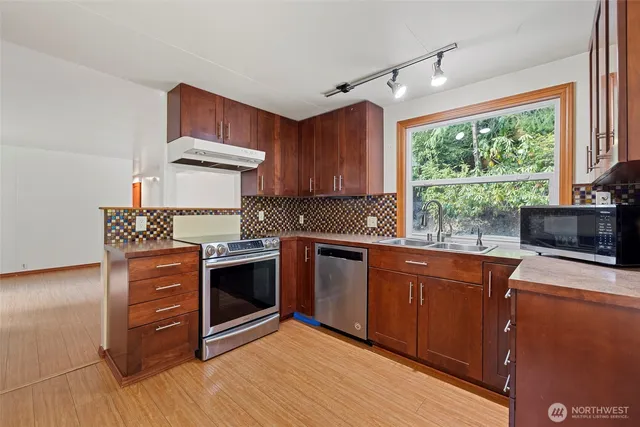 a kitchen with a stove a sink and a window