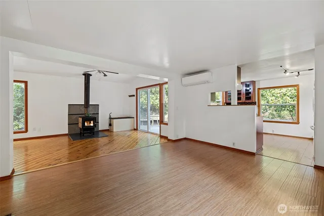 an empty room with windows and fireplace