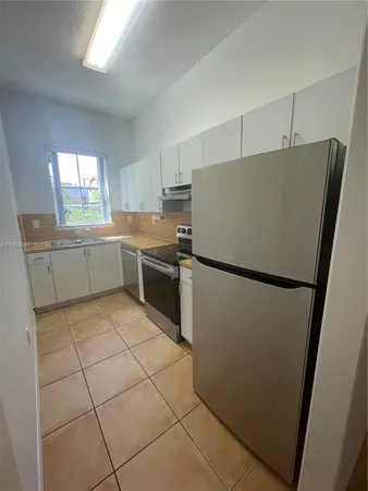 a kitchen with stainless steel appliances a refrigerator sink and cabinets