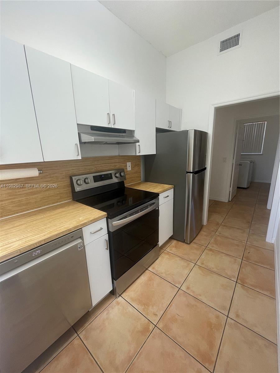 3421 Southwest 25th Street, Unit 1 Miami, FL 33133 - Photo 15 of 41 a kitchen with a refrigerator sink and cabinets