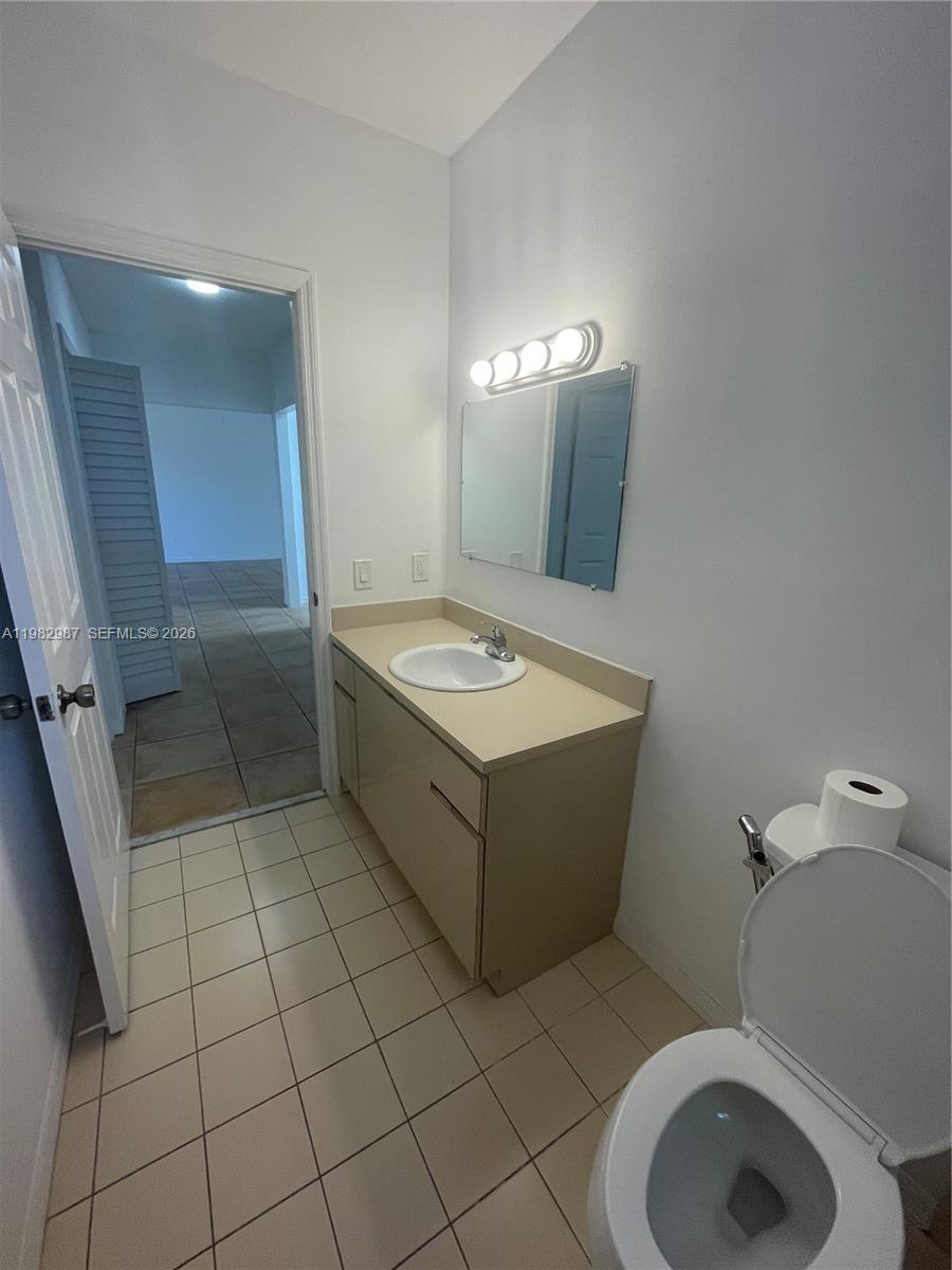 3421 Southwest 25th Street, Unit 1 Miami, FL 33133 - Photo 23 of 41 a bathroom with a sink a toilet and mirror