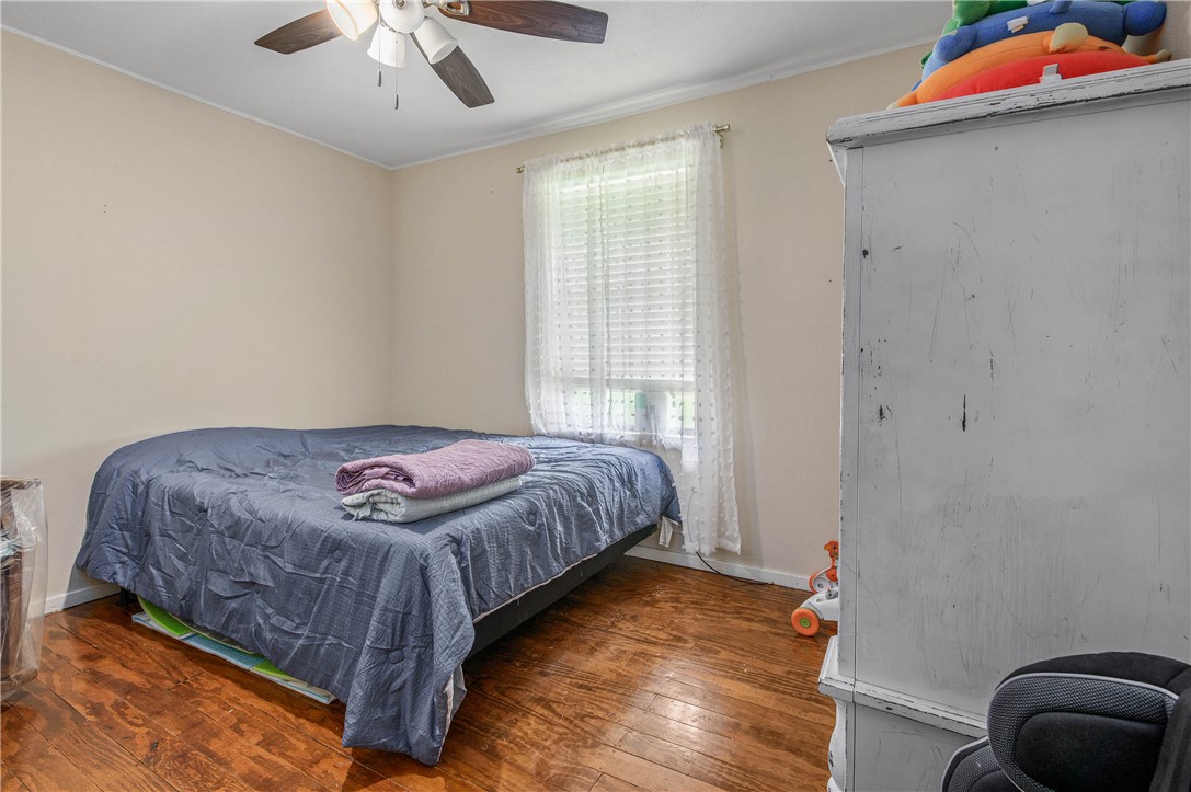 14452 Old Hearne Road Bryan, TX 77807 - Photo 10 of 17 a bedroom with a bed and a chandelier