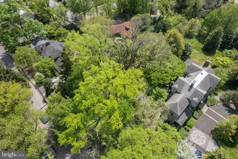 an aerial view of residential house with outdoor space and trees all around