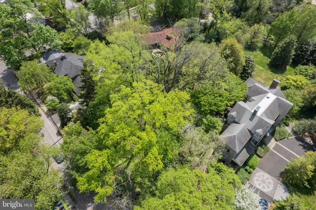 an aerial view of residential house with outdoor space and trees all around