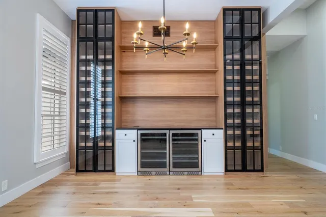 a kitchen with stainless steel appliances kitchen island granite countertop a refrigerator a sink and wooden cabinets