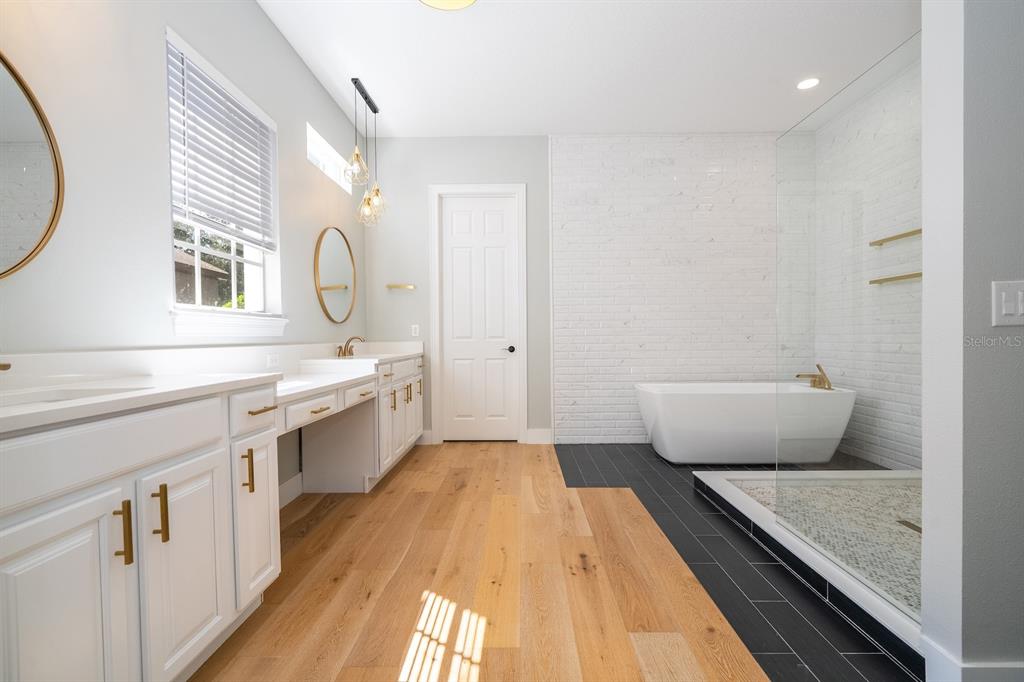 11213 Camden Park Drive Windermere, FL 34786 - Photo 65 of 99 a spacious bathroom with a granite countertop sink a mirror and a bathtub