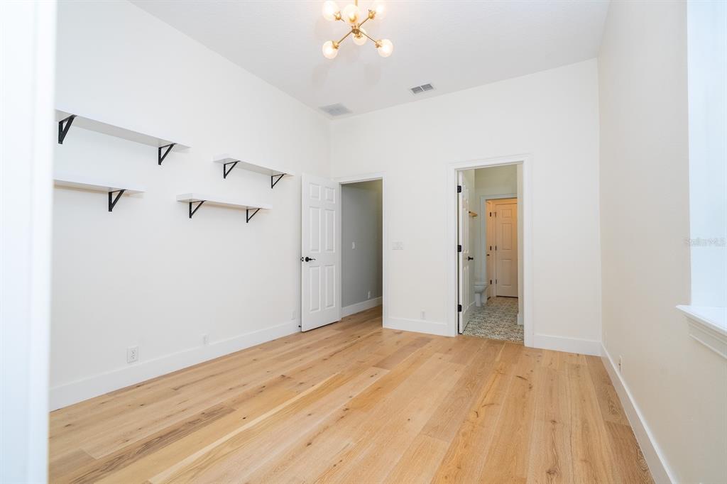 11213 Camden Park Drive Windermere, FL 34786 - Photo 91 of 99 a view of a big room with wooden floor and a ceiling fan
