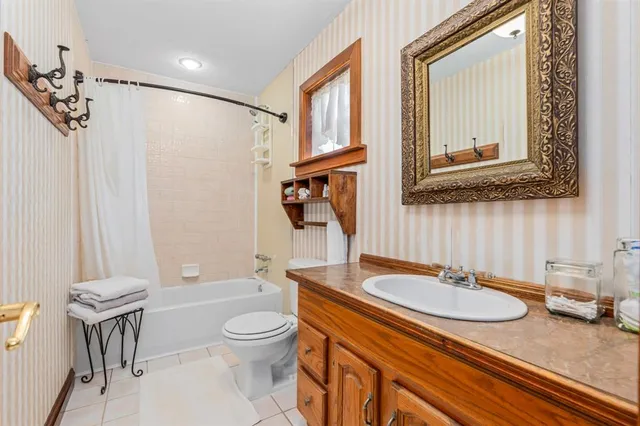 a bathroom with a granite countertop sink toilet a mirror and shower