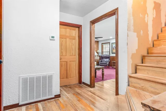 a view of a hallway with wooden floor and windows