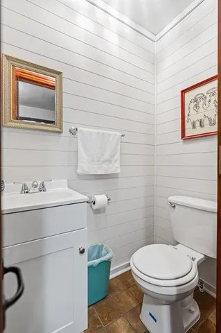 a bathroom with a toilet a sink and mirror