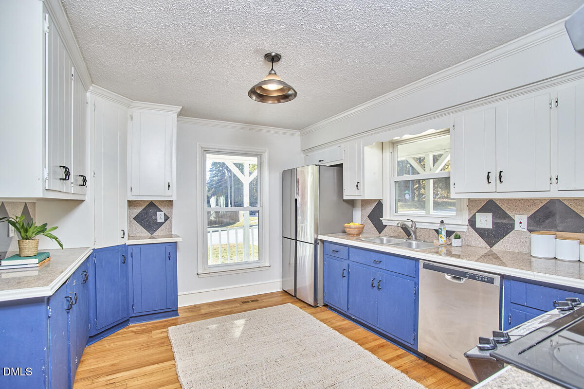 1918 Peppertree Street Durham, NC 27705 - Photo 16 of 45 a kitchen with a sink and wooden cabinets