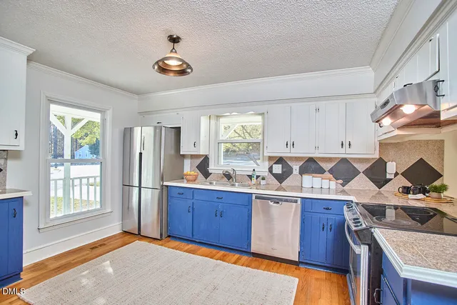 a kitchen with stainless steel appliances granite countertop a stove a sink dishwasher and a refrigerator with wooden floor