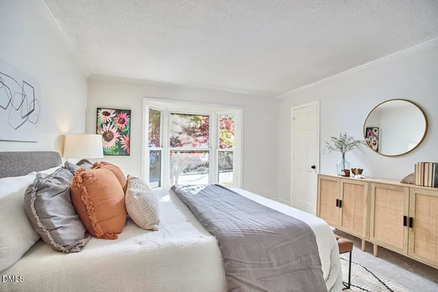 a bedroom with a bed a mirror and a window