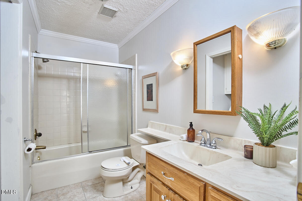 1918 Peppertree Street Durham, NC 27705 - Photo 35 of 45 a bathroom with a granite countertop sink a toilet a mirror and shower