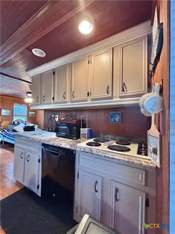 a kitchen with a sink a stove and cabinets