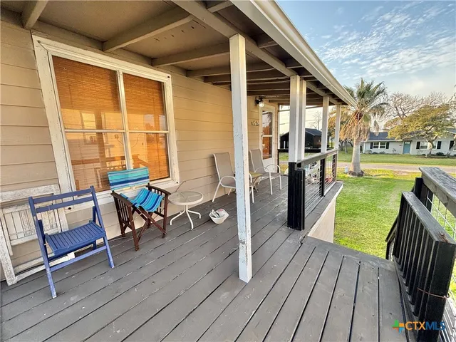 a view of a patio with dining table and chairs with wooden floor and fence