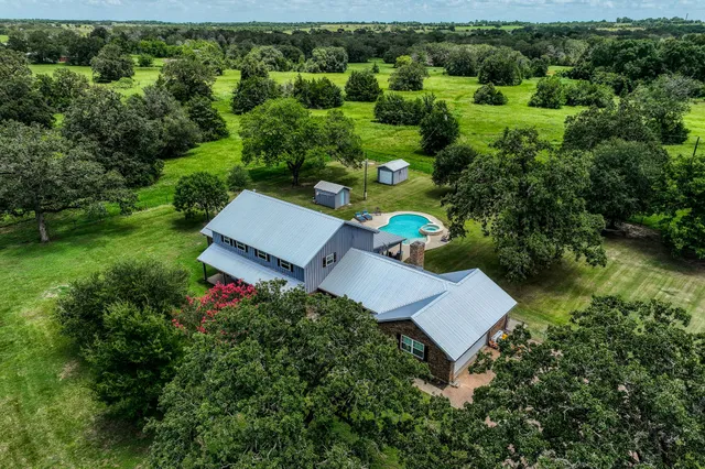an aerial view of a house with a yard