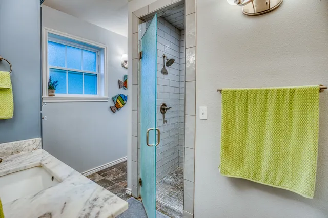 a bathroom with a granite countertop shower and a sink