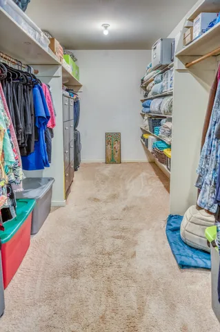a view of walk in closet with clothes and shoes